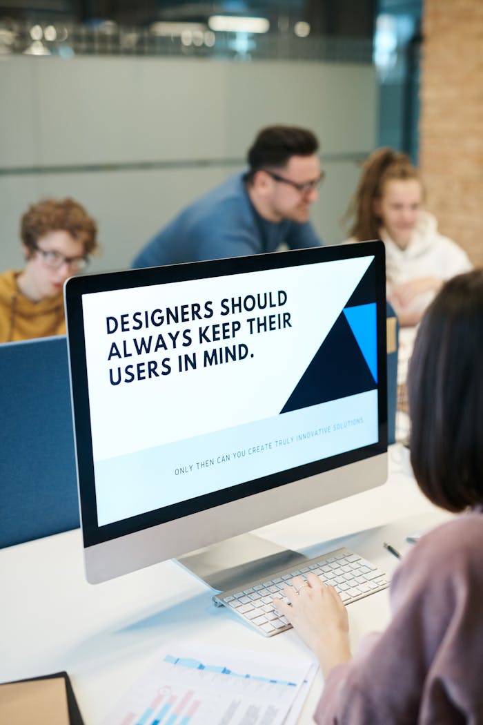 gallery-1 Group of designers collaborating in modern office space with computer.