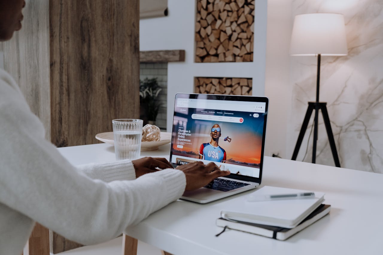 about-01 Faceless person using a laptop with online content in a cozy modern setting.